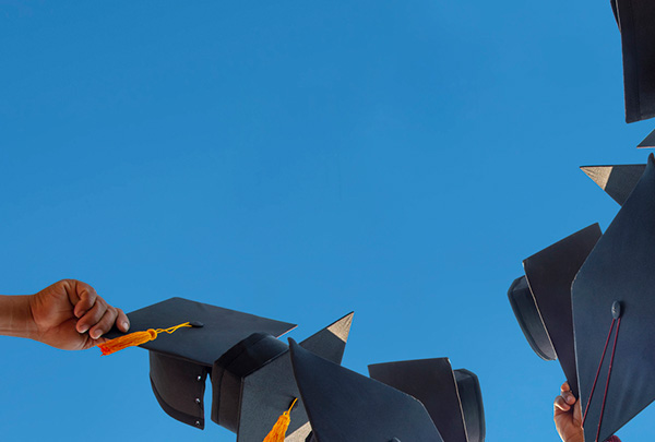 hats being thrown in air to celebrate graduation